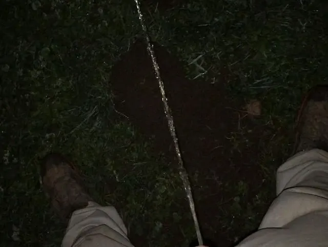 Pissen auf Erdhügel im Dunklen
